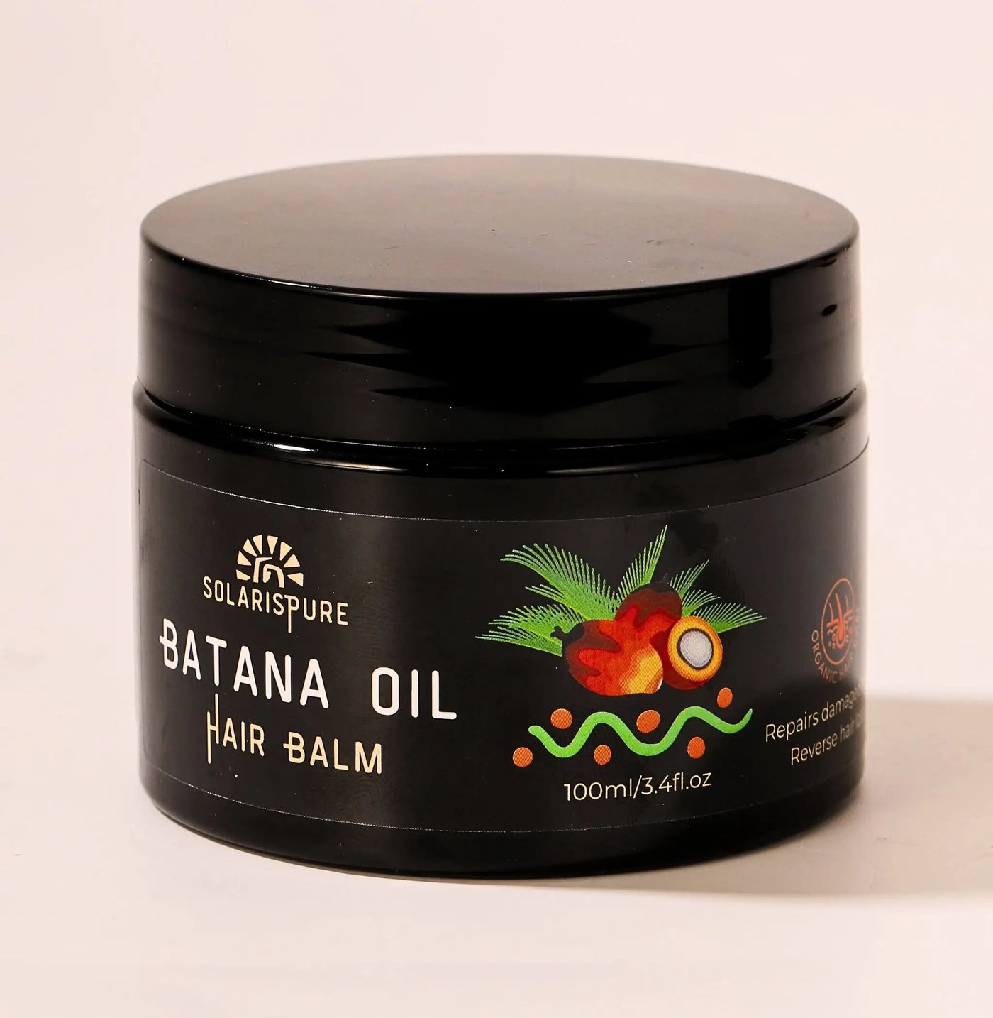 Black jar of Batana Oil Hair Balm with branding on a beige background